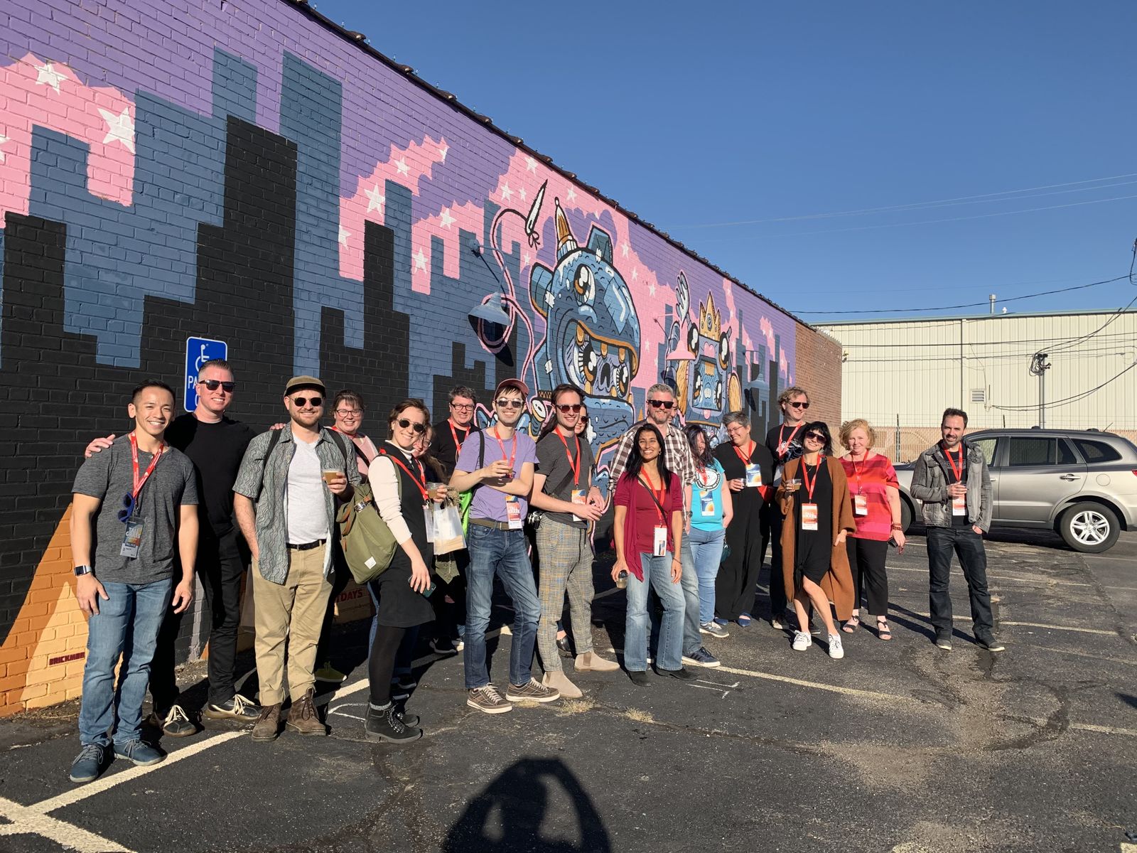 Tour guests together in front of a colorful downtown Wichita mural