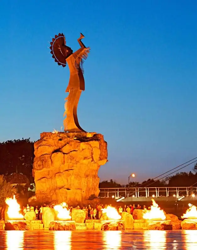 The Keeper of the Plains sculpture at dusk with the fire pots lit